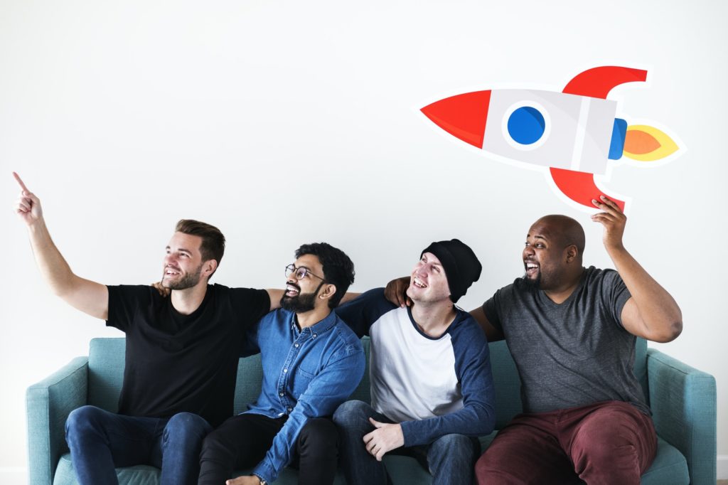 Group of diverse friends sitting on couch with spaceship icon